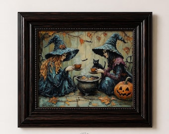 May include: A framed wall art print depicting two figures in pointed hats and dark robes sitting around a central cauldron. One figure has long red hair, the other has dark hair. A black cat, a carved jack-o'-lantern, and autumn leaves are visible.