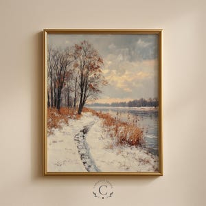 Puede incluir: Pintura de paisaje enmarcada que representa una escena invernal con un camino cubierto de nieve que conduce a un río. Árboles desnudos y hierbas de color marrón dorado bordean el camino. El cielo está nublado con destellos de sol.