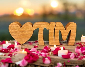 May include: Wooden letters spelling "TIM" with a heart in front of the letters. The letters are on a wooden surface with pink and red rose petals scattered around them. There are also small white candles on the surface.