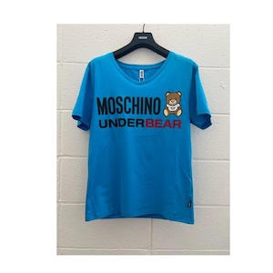 Puede incluir: Una taza de cerámica blanca con un asa negra y el texto "But First, Coffee" en negrita negra. La taza se encuentra sobre un fondo neutro, resaltando su diseño sencillo.