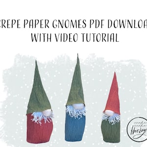 May include: Three handmade gnomes crafted from textured crepe paper with tall pointed hats and white fringed beards. The text reads CREPE PAPER GNOMES PDF DOWNLOAD WITH VIDEO TUTORIAL. A circular logo in the corner says make make Hooray.