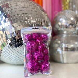Puede incluir: Una bolsa de pl&aacute;stico transparente, iridiscente y resellable llena de m&uacute;ltiples bolas de discoteca peque&ntilde;as y redondas de color rosa intenso. Cada bola de discoteca en miniatura est&aacute; cubierta con diminutos espejos cuadrados.