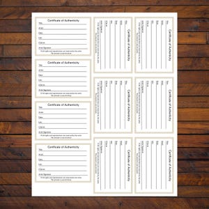 May include: A sheet of white paper with multiple rectangular certificates of authenticity. Each certificate has a decorative border and fields for title, artist, date, and COA number. The text "Certificate of Authenticity" is prominently displayed.
