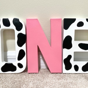Cow Print Farm Pink First Birthday Painted Letters O-N-E