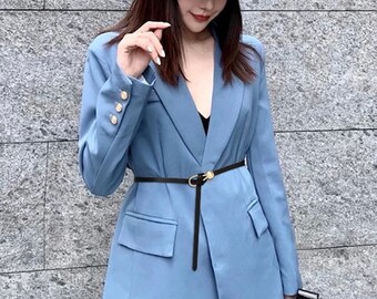 Könnte beinhalten: Ein hellblaues Blazer-Kleid mit goldenen Knöpfen und einem schwarzen Gürtel. Das Outfit beinhaltet einen passenden Jeans-Eimerhut. Das Kleid hat zwei Vordertaschen und eine taillierte Passform.