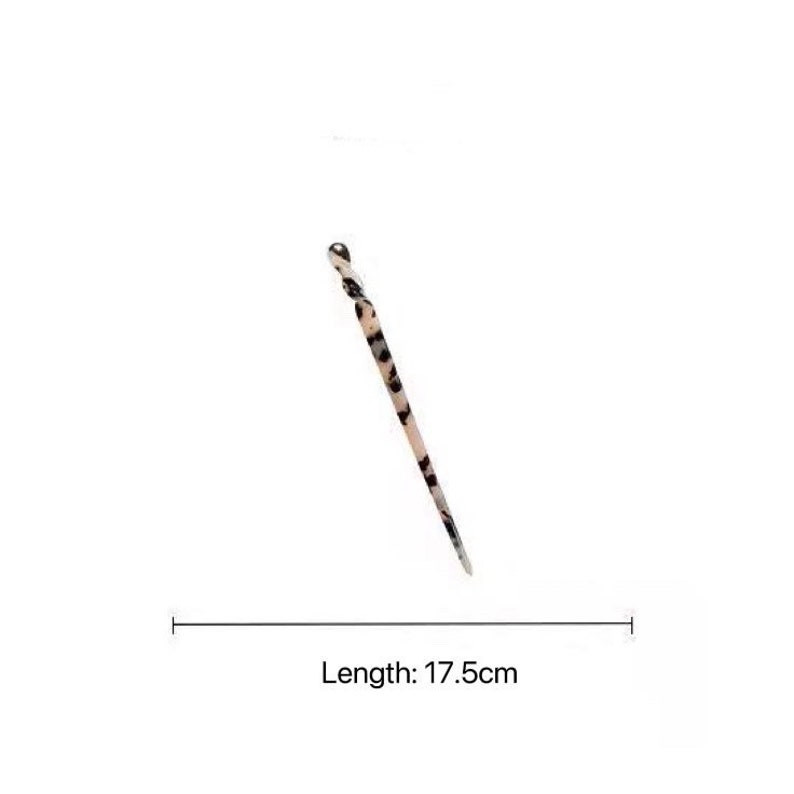 May include: A black and white patterned hair pin with a rounded end. The pin is 17.5 inches long.