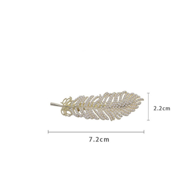 Peut inclure: Une barrette &agrave; cheveux dor&eacute;e en forme de plume, de 7,2 cm de long et 2,2 cm de large, orn&eacute;e de petites perles blanches rondes. La barrette pr&eacute;sente un design d&eacute;licat et orn&eacute;, parfait pour ajouter une touche d'&eacute;l&eacute;gance &agrave; toute coiffure.