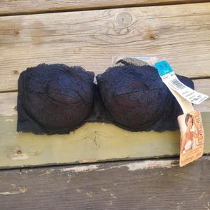 May include: Black lace strapless bra with a tag that reads "Lily of France" and "34 B".
