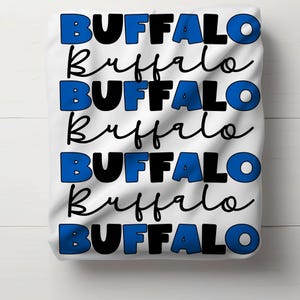 May include: White t-shirt with the word "BUFFALO" repeated six times in blue and black lettering.