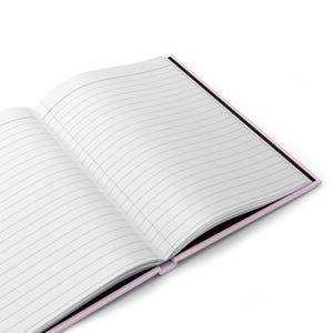 Op de afbeelding: Een roze en zwart gestreept notitieboekje met de pagina's open en plat liggend.