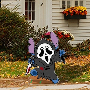 May include: A blue and black cartoon character with a white ghost mask holding a bloody knife. The character is standing on a brown surface in front of a house with a white siding and green bushes.