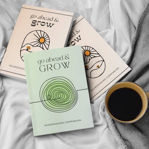 Peut inclure: Trois livres intitulés "go ahead & GROW" avec une illustration de soleil et de paysage, et le texte "MICRODOSING COMPANION". Un livre est vert clair avec un motif en spirale. Une tasse de café est à proximité.