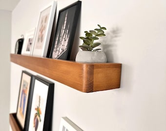 Handmade wooden wall-mounted floating shelf for photos, paintings, and frames.