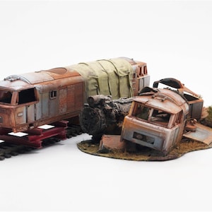 May include: A detailed model of a rusty, weathered train engine and a wrecked train car. The train engine is on a red support, and the scene includes a section of train track. The model has a post-apocalyptic theme.