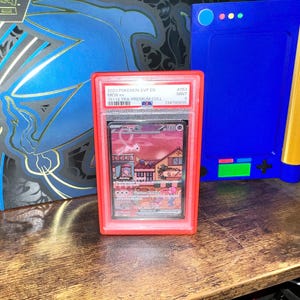 May include: A graded Pok&eacute;mon card in a red case. The card features the character Mew ex, with the text "2023 Pok&eacute;mon SVP EN" and "151 ULTRA-PREMIUM COLL". The case is labeled "MINT 9" and has a PA grading.