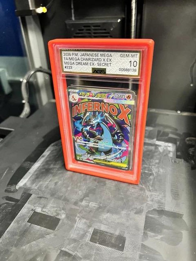 May include: A graded Japanese Mega Charizard X EX card in a red protective case. The card features a colorful illustration of a dragon-like creature with the text "Inferno X". The case is labeled with details including "GEM-MT 10".