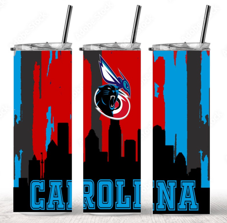 Puede incluir: Un vaso de acero inoxidable con un logotipo de los Carolina Panthers y un dise&ntilde;o de ciudad. El vaso es rojo, negro y azul con las palabras "CAROLINA" en azul.
