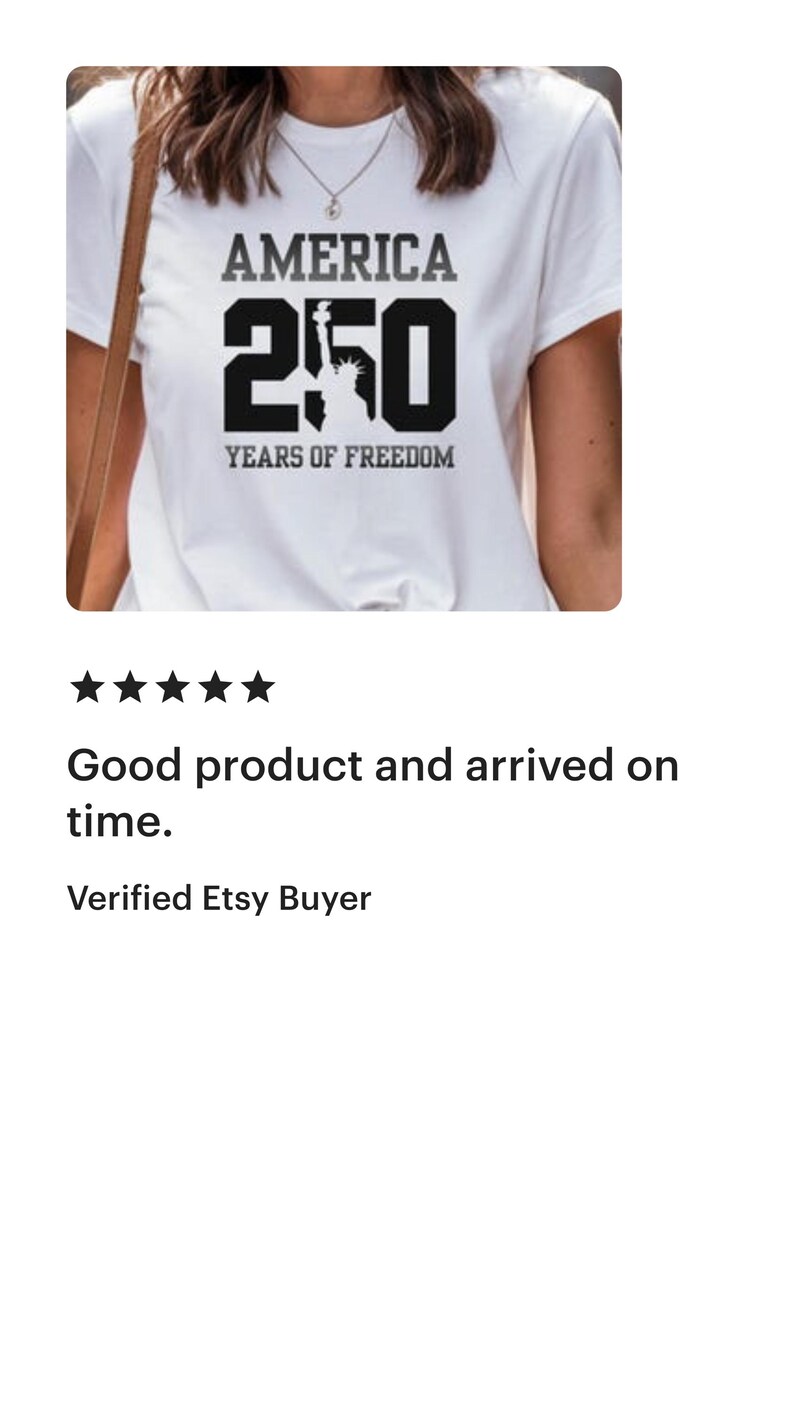 Puede incluir: Camiseta blanca con el texto "AMERICA 250 YEARS OF FREEDOM" en negro y gris. El n&uacute;mero 250 presenta una silueta de la Estatua de la Libertad. Un dise&ntilde;o sencillo y patri&oacute;tico.
