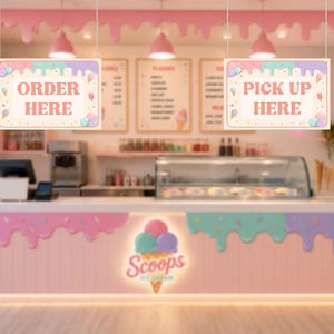 Op de afbeelding: Een interieur van een ijssalon met roze en pastelkleurige inrichting. Borden met de tekst "ORDER HERE" en "PICK UP HERE". De balie is voorzien van het logo "Scoops Ice Cream". Boven het hoofd hangen roze lampen aan het plafond.