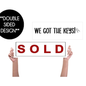 Pode incluir: Uma placa branca com o texto "WE GOT THE KEYS!" e uma pequena ilustração de duas chaves. Uma segunda placa branca com o texto "SOLD" em letras vermelhas. Um círculo preto com o texto "**DOUBLE SIDED DESIGN**".