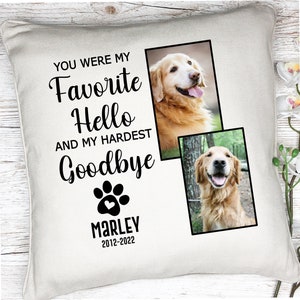 K&ouml;nnte beinhalten: Cremefarbenes quadratisches Kissen mit dem Text "YOU WERE MY FAVORITE HELLO AND MY HARDEST GOODBYE." Enth&auml;lt einen Pfotenabdruck und den Namen "MARLEY 2012-2022." Zwei Fotos eines Golden Retrievers sind auf dem Kissen abgebildet.