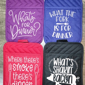 Könnte beinhalten: Vier verschiedene Topflappen mit lustigen Sprüchen über Essen. Der erste ist lila mit dem Text "What's for dinner?" Der zweite ist blau mit dem Text "What the fork is for dinner." Der dritte ist rot mit dem Text "Where there's smoke there's dinner." Der vierte ist schwarz mit dem Text "What's shakin' bacon."