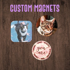 Könnte beinhalten: Drei personalisierte Magnete mit Holz Hintergrund. Ein Magnet zeigt eine Katze mit einem weißen und grauen Streifenmuster auf einem blauen und rosa Batik-Hintergrund. Ein weiterer Magnet zeigt eine Nahaufnahme des Gesichts einer gestreiften Katze. Der dritte Magnet ist ein rosa und weißer Batik-Kreis mit dem Text "you are" in Kursivschrift und den Wörtern "fähig, geliebt, würdig, wichtig, stark, freundlich" rund um den Text.