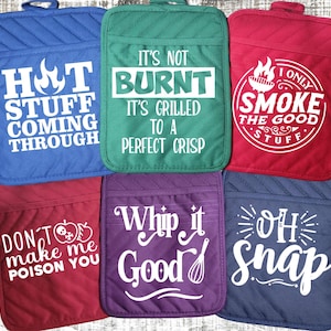 May include: Set of six colorful pot holders with funny sayings. The sayings include "Hot Stuff Coming Through", "It's Not Burnt It's Grilled to a Perfect Crisp", "I Only Smoke the Good Stuff", "Don't Make Me Poison You", "Whip it Good", and "Oh Snap".