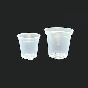 Può includere: Due vasi di plastica trasparente di diverse dimensioni. I vasi hanno un bordo leggermente svasato e fori di drenaggio sul fondo. I vasi sono trasparenti, consentendo di vedere il terreno e le radici. Lo sfondo è nero pieno.