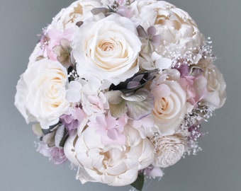 May include: A white and blush bridal bouquet featuring roses, peonies, and hydrangeas.