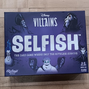 Puede incluir: Una caja de juego de mesa de color p&uacute;rpura con el t&iacute;tulo "Disney Villains Selfish" en texto blanco. La caja presenta im&aacute;genes de villanos de Disney, incluyendo a &Uacute;rsula, Mal&eacute;fica y Scar. El juego es para 2-5 jugadores, de 10 a&ntilde;os en adelante, y dura 20 minutos.