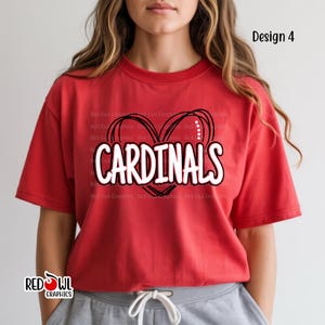May include: Red t-shirt with the word "CARDINALS" in white, outlined in black, inside a black heart design. The shirt also features the text "Design 4" and the "RED OWL GRAPHICS" logo.