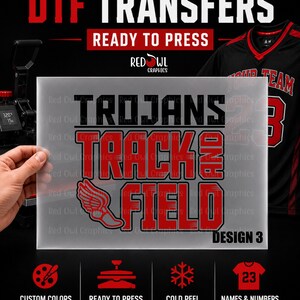 May include: A rectangular sheet of clear film featuring the black and red text TROJANS TRACK AND FIELD with a red winged shoe graphic. The design is labeled DESIGN 3. Below are icons for custom colors, ready to press, cold peel, and names and numbers.
