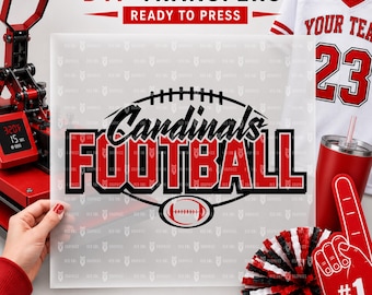 May include: A clear DTF transfer sheet featuring the black and red text Cardinals FOOTBALL with a football graphic. The sheet is held in front of a heat press, a white jersey with the number 23, a red tumbler, and a red and black pom-pom.