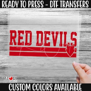 May include: A red "Red Devils" DTF transfer with a devil head logo. The words "READY TO PRESS - DTF TRANSFERS" and "CUSTOM COLORS AVAILABLE" are printed above and below the design. The Red Owl Graphics logo is in the bottom left corner.