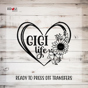 May include: A black graphic design featuring a heart outline, the text GIGI life, and a cluster of sunflowers. The logo RED OWL GRAPHICS appears in the top left corner, and the text READY TO PRESS DTF TRANSFERS is printed at the bottom.