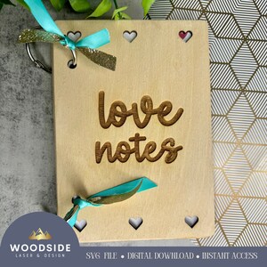 Puede incluir: Un diario de madera para notas de amor con una cinta turquesa y purpurina dorada. El diario tiene un llavero y recortes en forma de corazón. El texto "love notes" está grabado en la parte delantera.