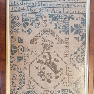 Könnte beinhalten: Ein gerahmter Stich mit einem Kreuzstich-Design, das einen Vogel, Blumen und geometrische Muster zeigt. Der Stich ist mit 1790 datiert und mit "Ann Lister" signiert.