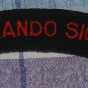 May include: Black fabric patch with the text "COMMANDO SIGNALS" in red embroidery.