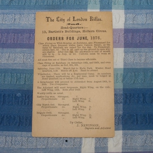 May include: A vintage, black and white printed card with the title "The City of London Rifles" and the text "Orders for June, 1876". The card lists the orders for the month of June, including class firing, marching out, and brigade drill.