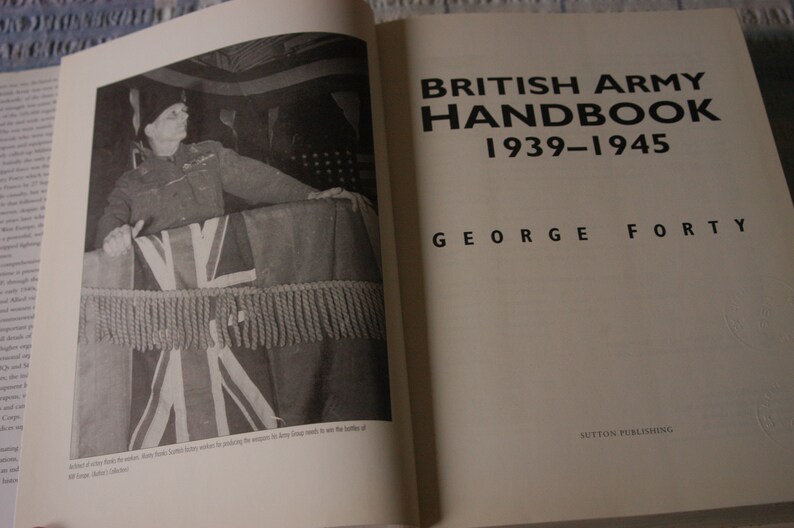 K&ouml;nnte beinhalten: Ein Schwarzwei&szlig;foto eines Mannes in Milit&auml;runiform, der hinter einem Podium steht, das mit einer Union Jack-Flagge bedeckt ist. Der Buchtitel lautet "British Army Handbook 1939-1945" und "George Forty".