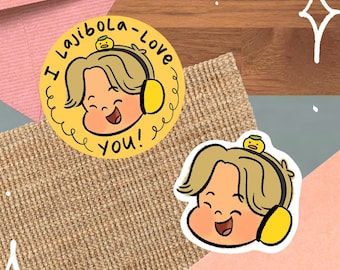 May include: Two yellow and white stickers with a cartoon character wearing headphones. The text on the sticker says "I lajibola - love you!"