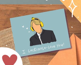 May include: A greeting card with a light blue background features an illustration of a person wearing yellow headphones and a black jacket. The text "I LachimoLa-Love You!" is written on the card. A red heart is visible in the lower left corner.