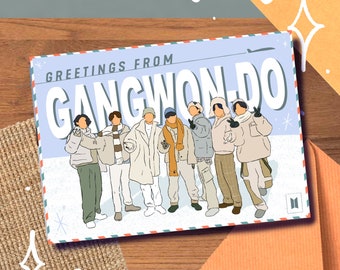 May include: A postcard with the text "Greetings from Gangwon-do" and a cartoon illustration of a group of people wearing winter clothing. The postcard has a blue background with a white border and a red airplane stamp.