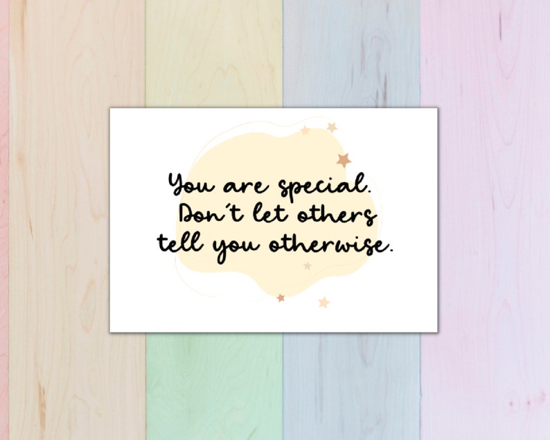 Puede incluir: Una tarjeta blanca con una forma abstracta amarilla y dorada y estrellas doradas. La tarjeta tiene el texto "You are special. Don't let others tell you otherwise."