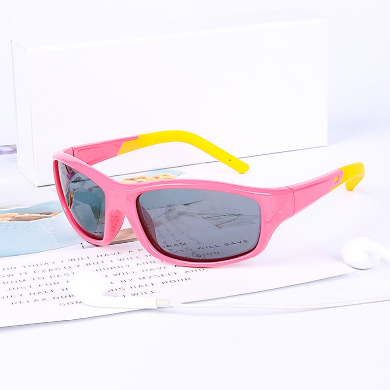 Puede incluir: Gafas de sol para ni&ntilde;os de color rosa y amarillo con lentes grises. Las gafas tienen un dise&ntilde;o deportivo y son perfectas para proteger los ojos de los ni&ntilde;os del sol.