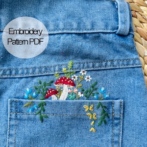 May include: Embroidered denim pocket with red and white mushrooms, green leaves, and blue and yellow flowers. The text "Embroidery Pattern PDF" is on a white circle.
