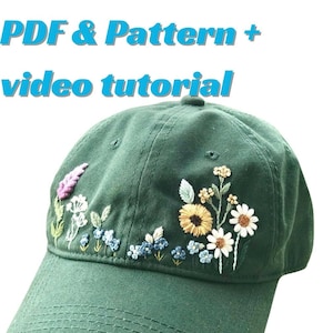 May include: A green baseball cap with embroidered flowers in shades of pink, yellow, white, and blue. The text "PDF & Pattern + video tutorial" is visible above the cap.