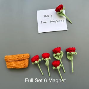 May include: A set of handmade crochet magnets featuring red roses with green stems and leaves. Includes a small orange crochet basket and a note that says "Hello! I am Magnet". The text "Full Set 6 Magnet" is also visible.