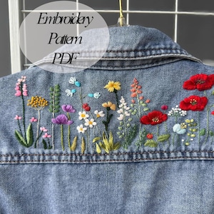 May include: Embroidered denim jacket featuring a floral design. The embroidery includes a variety of flowers in shades of pink, red, yellow, blue, and green. The text "Embroidery Pattern PDF" is visible at the top of the image.